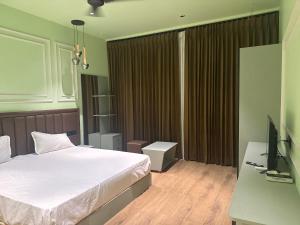 a bedroom with a bed and a desk and a television at Kuber hotel in Valsād