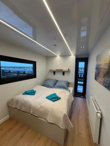 a bedroom with a bed with blue towels on it at Hausboot Nikolai Stralsund in Stralsund
