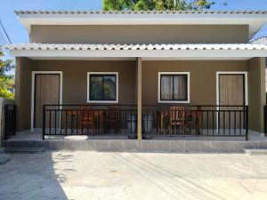 a house with a balcony with tables and chairs at Son House in Ban Thalat Choeng Thale