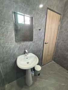 a bathroom with a sink and a mirror at Son House in Ban Thalat Choeng Thale