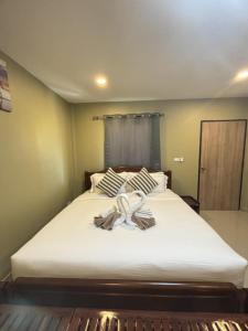 a bedroom with a large bed with a bow on it at Son House in Ban Thalat Choeng Thale