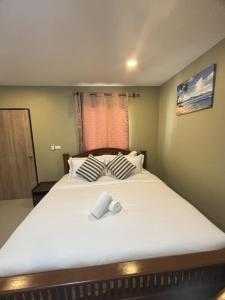 a bedroom with a large bed with two pillows at Son House in Ban Thalat Choeng Thale