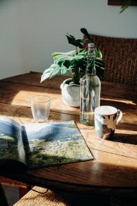 a wooden table with a book and a bottle on it at La Villa d'Hélène Chambre d'hôtes BnB - Cluses - Parking Voiture - Moto - Vélo in Cluses