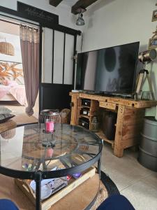 a living room with a tv and a glass table at Maison du bonheur in Seur