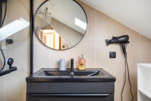 a bathroom with a sink and a mirror at Gîte Bretzel et Grappe in Ingersheim +18 photos