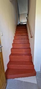 a stairway with red carpeted stairs in a building at SarahScope - chambre cosy avec salle de bain privée proche Futuroscope in Saint-Georges-lès-Baillargeaux +2 photos