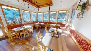 a restaurant with tables and chairs and windows at Pension Kristall in Schladming