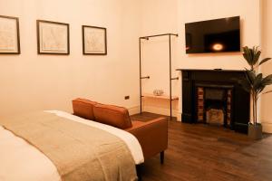 a bedroom with a bed and a tv and a fireplace at Lovely Studio Flat on Bath Road - Flat 2 in Bristol