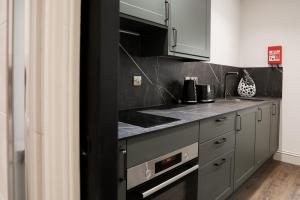a kitchen with gray cabinets and a counter top at Lovely Studio Flat on Bath Road - Flat 2 in Bristol