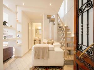 a living room with a white couch and a staircase at Lemon Tree House in Bari