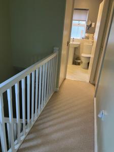 a bathroom with a staircase with a toilet and a sink at The Pudd in Aylesbury