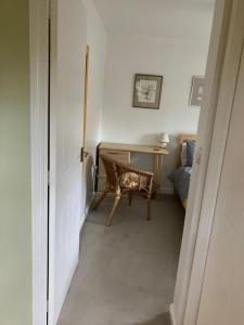 a hallway with a desk and a chair in a room at The Pudd in Aylesbury