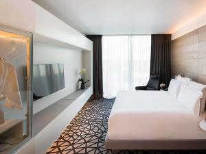 a hotel room with a large bed and a tv at Pullman Sydney Airport in Sydney +170 photos
