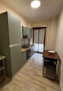 a kitchen with a counter and a table in it at Grazioso Appartamento Ostia Roma in Lido di Ostia