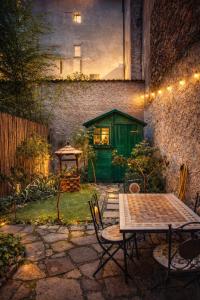 a patio with a table and chairs and a green shed at Garden Prina-250mt Clinica Zucchi-Monza in Monza