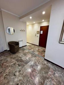 an empty room with a chair and a mirror at Grazioso Appartamento Ostia Roma in Lido di Ostia +2 photos