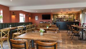 a restaurant with tables and chairs and a bar at Castle Brake Holiday Park in Woodbury