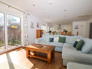 a living room with a couch and a table at Bluebell Cottage in Maidstone
