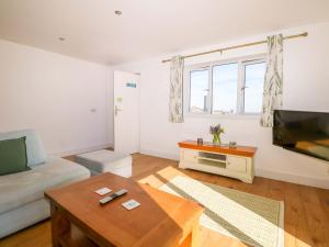 a living room with a couch and a tv at Bluebell Cottage in Maidstone