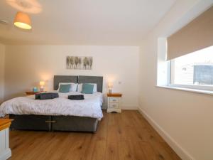 a bedroom with a large bed and a window at Bluebell Cottage in Maidstone