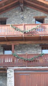 un balcón de madera con guirnaldas de Navidad en Maison de la Place, en Doues