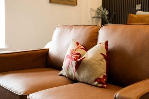 a brown couch with two pillows on it at Lovely Studio Flat on Bath Road - Flat 8 in Bristol