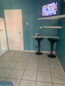 a room with a table and a tv on a wall at Hotel&Hostal Trinidad in La Ceiba +15 photos
