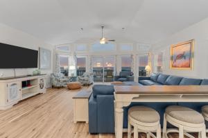 a living room with a blue couch and a tv at 5725 - A Dream Vacation in Nags Head