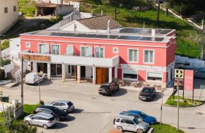 a red building with cars parked in a parking lot at Guesthouse Solar do Mar in Silveira