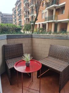 a patio with two chairs and a table with a potted plant at TM My Home in Novara