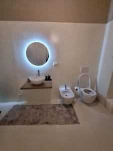 a bathroom with a sink and a toilet and a mirror at TM My Home in Novara +6 photos
