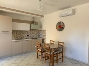 a kitchen with a table and chairs and a clock on the wall at FUORI PORTA NUOVA in Sarzana
