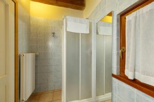 a shower with a glass door in a bathroom at La polse di San Pieri in Zuglio