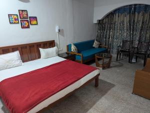 a bedroom with a bed and a blue couch at Pavitra Beach Home in Baga