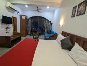 a bedroom with a large bed with a red blanket at Pavitra Beach Home in Baga