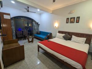 a bedroom with a bed and a living room at Pavitra Beach Home in Baga