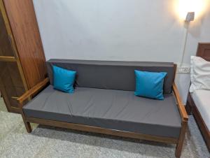 a bed with two blue pillows in a room at Pavitra Beach Home in Baga +1 photo