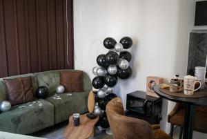 a living room with a green couch and a bunch of balloons at Chocolat Paris, Cozy apartment in Levallois-Perret