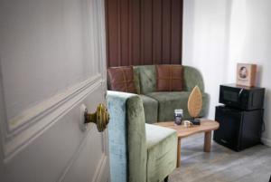 a living room with a couch and a chair and a table at Chocolat Paris, Cozy apartment in Levallois-Perret