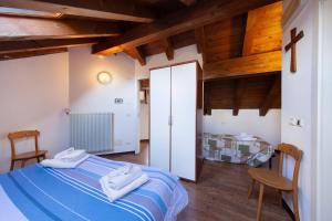 a bedroom with a blue bed and wooden ceilings at La polse di San Pieri in Zuglio