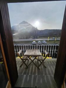 a table on a porch with a view of a mountain at Chambre La Charolaise in Aubessagne