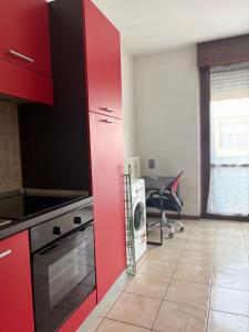 a kitchen with red cabinets and a washing machine at FGH Apartment ZONA FIERA FREE PARKING in San Polo