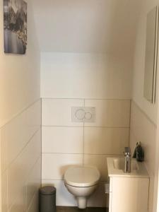 a white bathroom with a toilet and a sink at Penthouse Vero I Bergblick I Seenähe I Hallstatt in Obertraun +14 photos