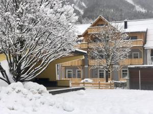a house with snow covered trees in front of it at Penthouse Vero I Bergblick I Seenähe I Hallstatt in Obertraun