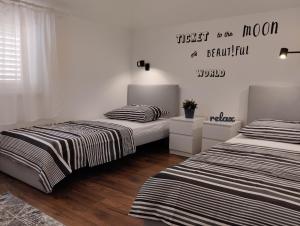 a bedroom with two beds and a sign on the wall at Keti House Apartments in Vela Luka