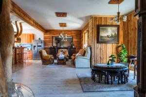 a living room with wooden walls and a table and chairs at Chata u Szymczaka in Łopuszna