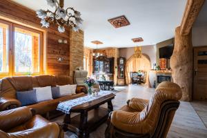 a living room with leather furniture and a table at Chata u Szymczaka in Łopuszna