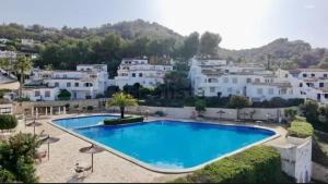 a large blue swimming pool in front of white houses at Casa Tere in Benitachell