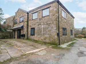 an old brick building with windows on it at 2 Manorhouse Farm in Rochdale