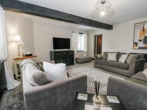a living room with two couches and a tv at 2 Manorhouse Farm in Rochdale